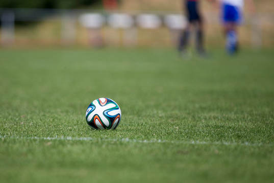 En fotboll ligger på fotbollsplanen