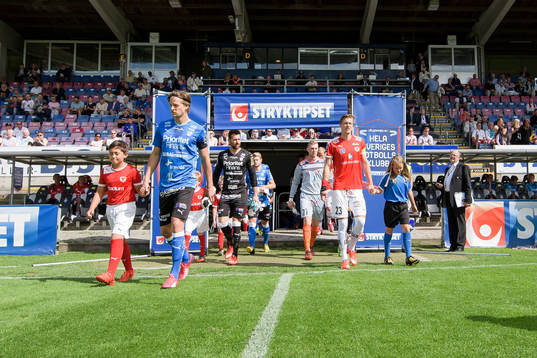 Spelarna kommer in på planen före fotbollsmatchen i