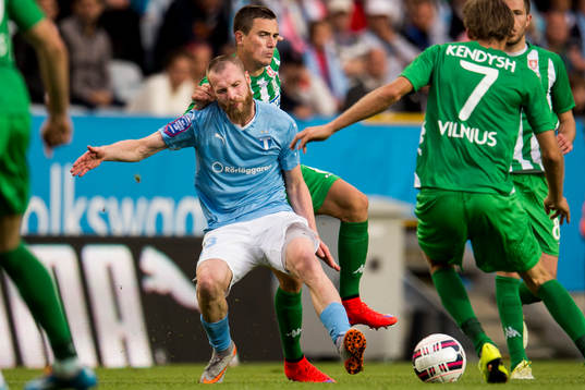 Malmö FFs Jo Inge Berget blir dragen i axeln av Zalgiris