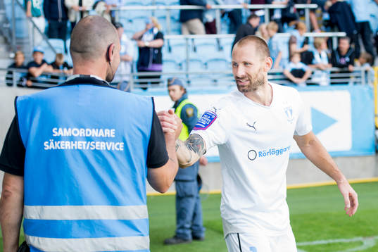 Malmö FFs målvakt Johan Wiland tackas av en vakt