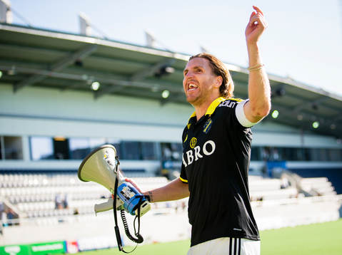 s Nils-Eric Johansson med en megafon i handen firar med