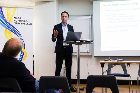 En representant från företaget Deloitte presenterar en