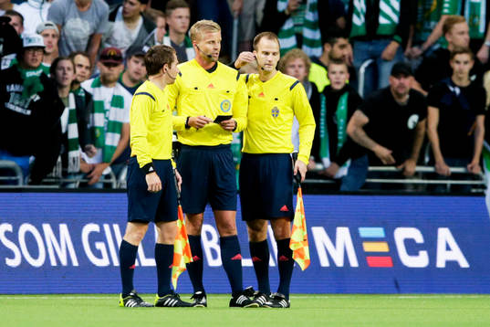 Domaren Glenn Nyberg konfererar med sina assisterande