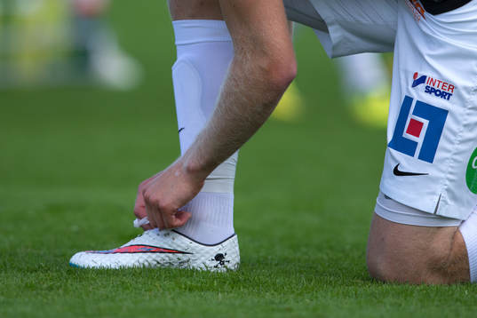 En Falkenbergs spelare knyter skorna före fotbollsmatchen