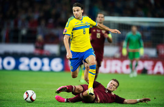 Sveriges Albin Ekdal undviker en tackling från Rysslands