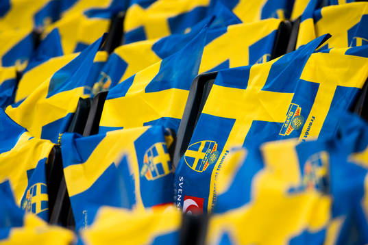Svenska flaggor ligger utlagda på läktaren