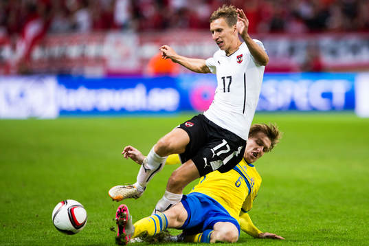 Sveriges Emil Forsberg glidtacklar Österrikes Florian Klein