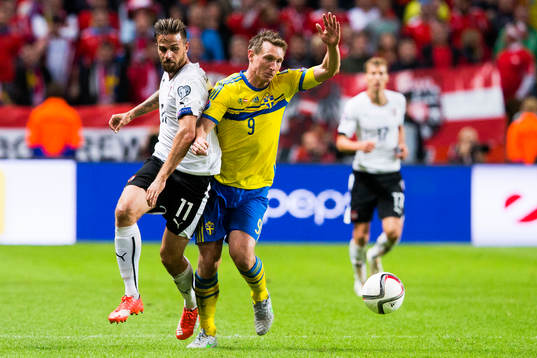 Österrikes Marek Harnik i kamp om bollen med Sveriges Kim