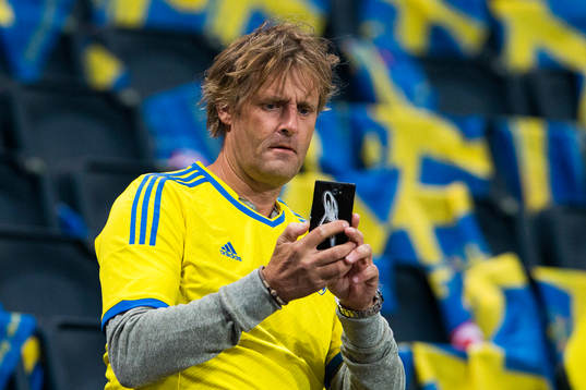 En Svensk supporter tar kort med sin mobiltelefon