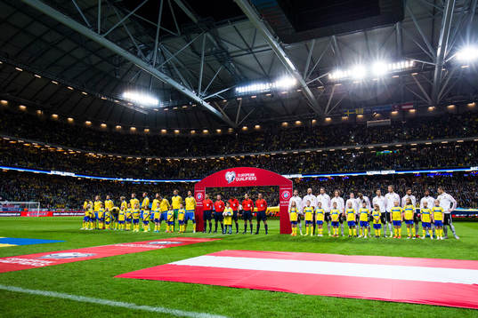 Sveriges och Österrikes spelare ställer upp på plan