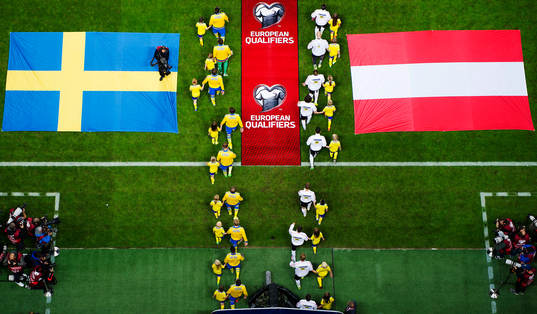 Sveriges och Österrikes spelare äntrar planen