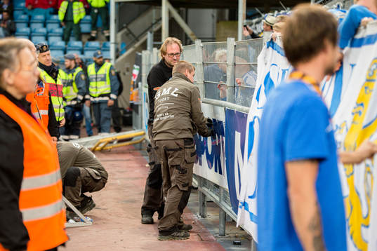 Arbetare plockar ner ett stängsel så länge är matchen
