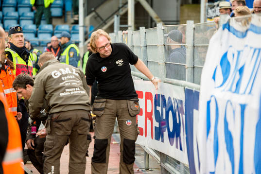 Arbetare plockar ner ett stängsel så länge är matchen