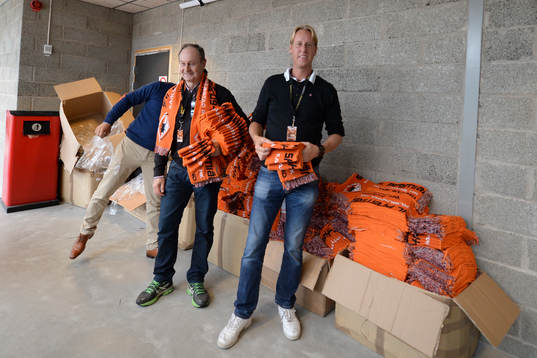 två funktionärer delar ut halsdukar innan ishockeymatchen