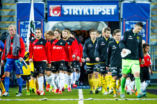 Spelarna går ut på planen före fotbollsmatchen i