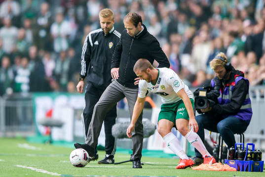 s tränare Andreas Alm håller bort bollen från Hammarbys