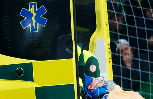 Hammarbys Erik Israelsson förs in på bår i en ambulans