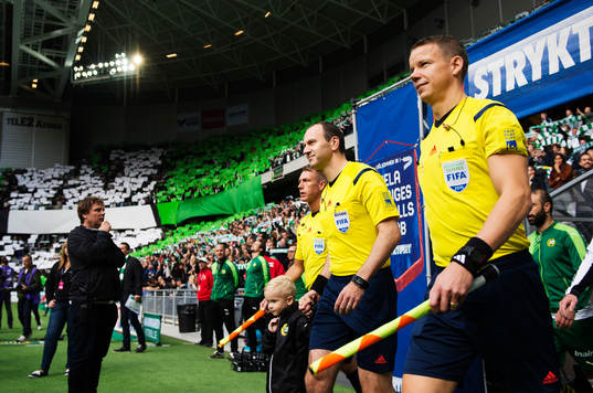 Domare Jonas Eriksson gör entré till fotbollsmatchen i