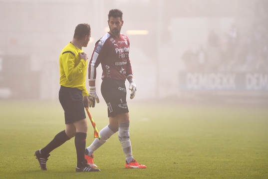 En linjedomare och Halmstads målvakt Stojan Lukic i samtal