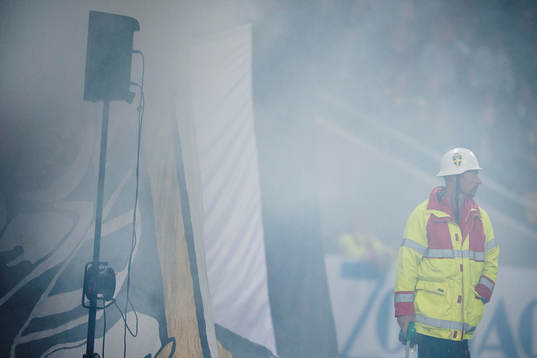 En man från räddningstjänsten står i rök