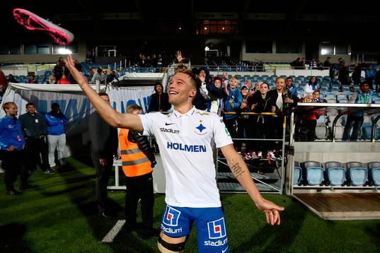 Norrköpings Nicklas Bärkroth kastar fotbollsko till barnen