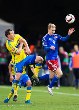 Sveriges Kim Källström i en luftduell med Liechtensteins