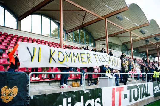 En banderoll med texten "vi kommer tillbaka" på AIKs