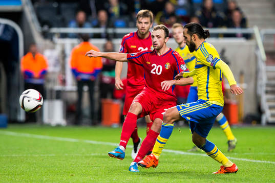Moldaviens Alexandru Vremea i kamp om bollen med Sveriges