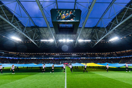 En stor svensk flagga på plan innan fotbollsmatchen i
