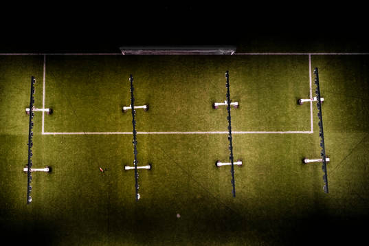 Lampor lyser med artificiellt solljus på gräsplanen