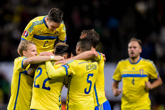 Sveriges spelare med Mikael Lustig (hoppande) jublar