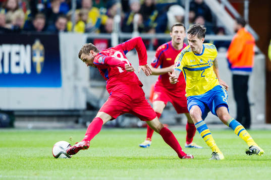 Sveriges Mikael Lustig i kamp om bollen med Moldaviens
