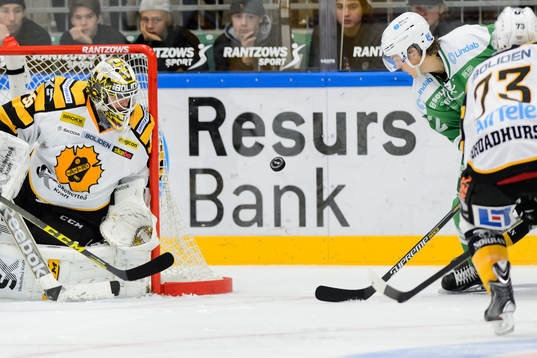 Rögles Daniel Sylwander (h) försöker trycka in en puck