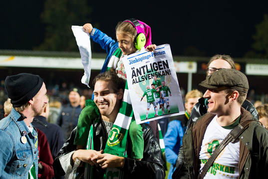 En ung supporter med hörselkåpor och löpsedlar med