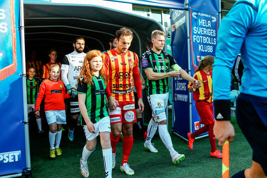 Spelarna på väg in till planen före fotbollsmatchen i