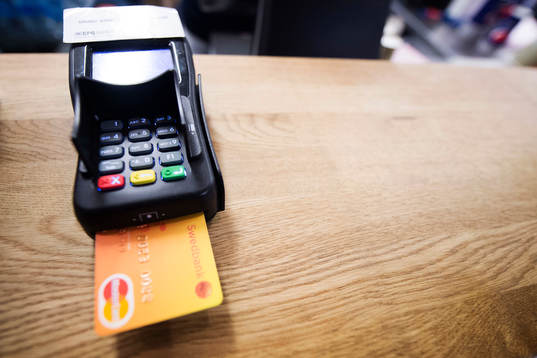 En kund betalar med sitt kontokort i en betalautomat