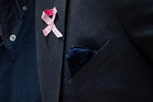 En tränare bär ett rosa band för att stötta kampen mot