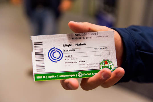 En besökare håller upp matchbiljetten