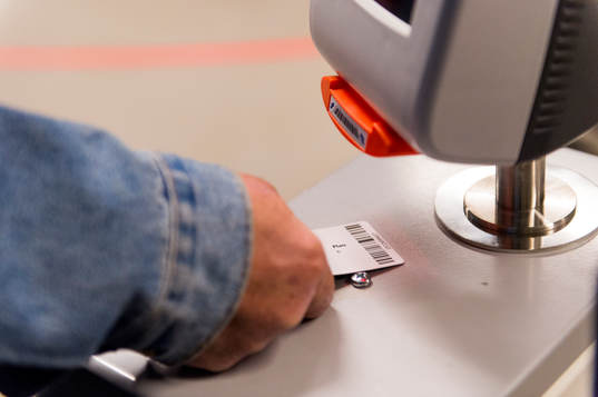 En åskådare scannar sin matchbiljett i insläppet till
