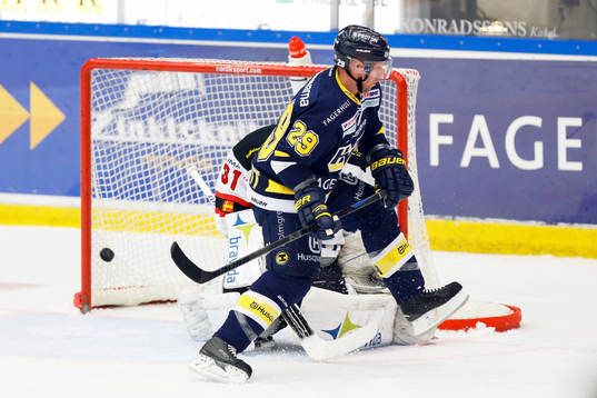 s Chris Abbott styr in pucken bakom ma+målvakt Mika Noronen