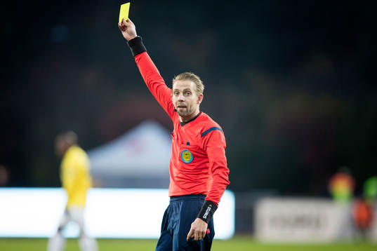 Domare Johan Hamlin delar ut ett gult kort