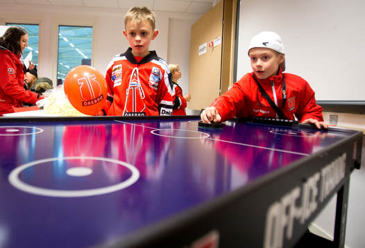 Några juniorer spelar air hockey