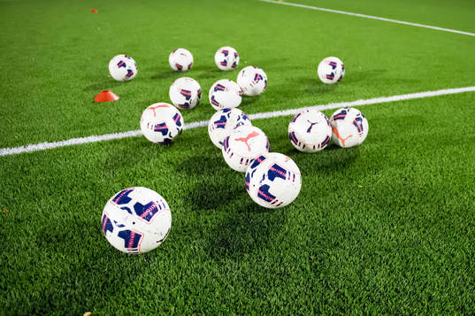 Fotbollar på en konstgräsplan