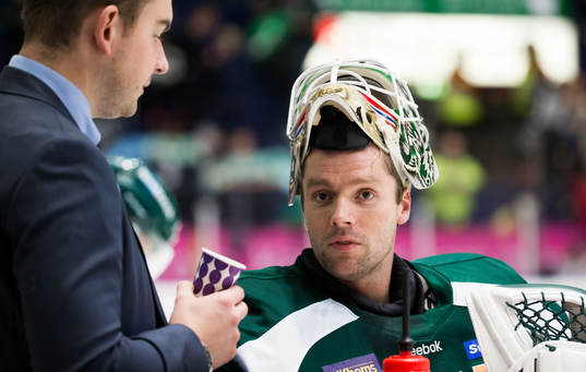 Färjestads målvakt Lars Haugen med mask pannan pratar med