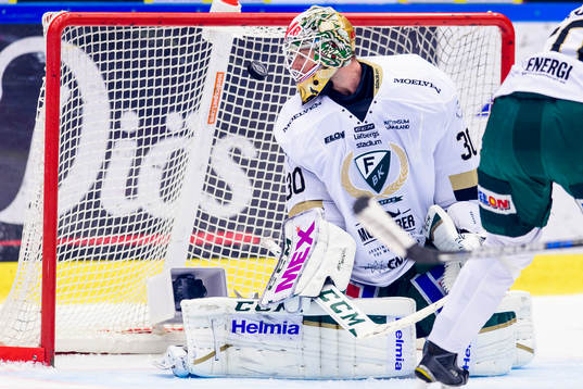 Färjestads målvakt Lars Haugen ser pucken träffa ribban