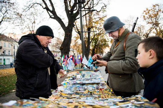 En beväpnad militär köper pins på en marknad en