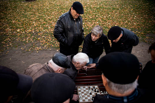 Äldre herrar spelar schack på en parkbänk en