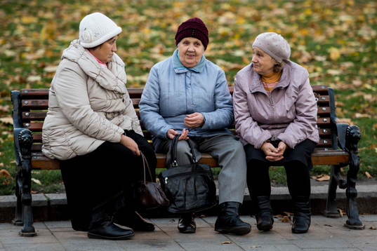 Ukrainska damer sitter på en parkbänk en