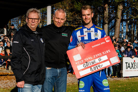 En representant från svenska spel lämnar över en check