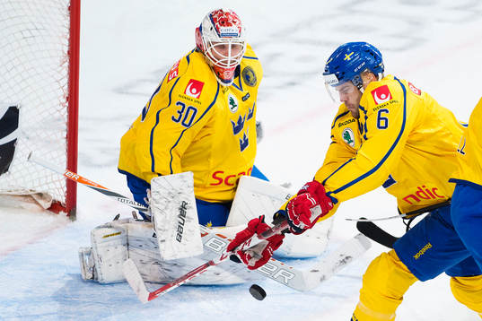 Sveriges Patrik Hersley rensar framför målvakt Viktor